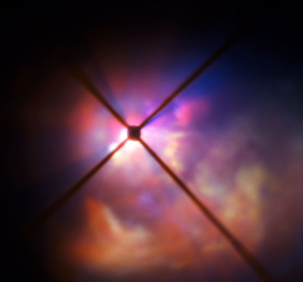 The star VY Canis Majoris is a red hypergiant, one of the largest known stars in the Milky Way. It is 30–40 times the mass of the Sun and 300 000 times more luminous. In its current state, the star would encompass the orbit of Jupiter, having expanded tremendously as it enters the final stages of its life. New observations of the star using the SPHERE instrument on the VLT have clearly revealed how the brilliant light of VY Canis Majoris lights up the clouds of material surrounding it and have allowed the properties of the component dust grains to be determined better than ever before. In this very close-up view from SPHERE the star itself is hidden behind an obscuring disc. The crosses are artefacts due to features in the instrument.