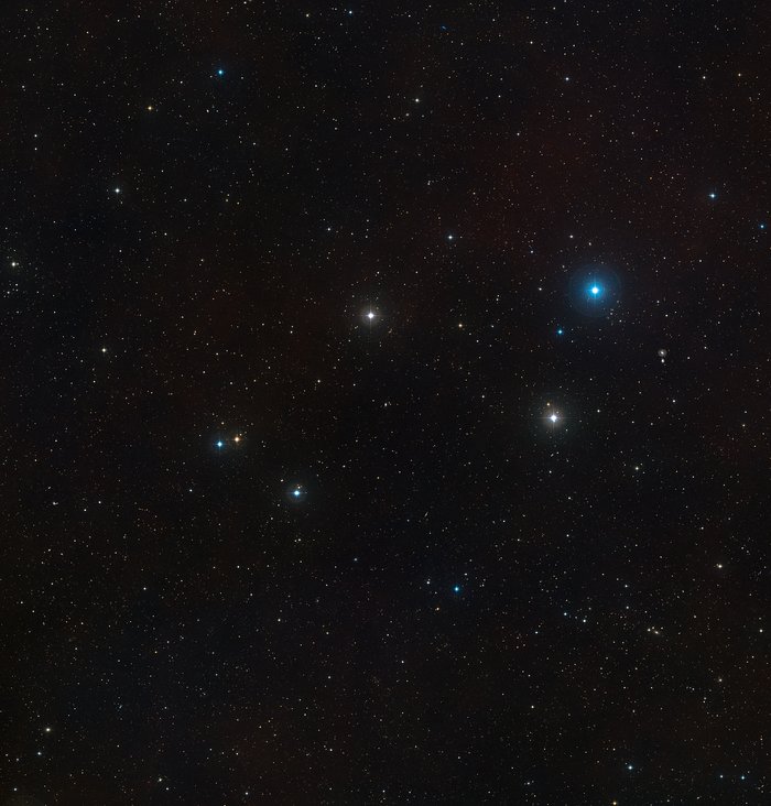 This wide-field image shows the sky around the faint active galaxy Markarian 1018. The picture was assembled from images forming part of the Digitized Sky Survey 2. The galaxy itself is at the centre of the picture and faint evidence of its recent merger can be seen in the form of tails and loops.